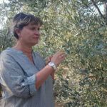 une femme tient dans sa main une branche d'olivier.