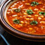 plat rond avec des pois chiche et une sauce rouge